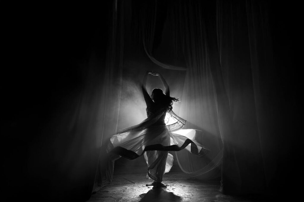 pexels-photo-28825952 Captivating silhouette of a traditional Indian dancer performing under soft lighting indoors.